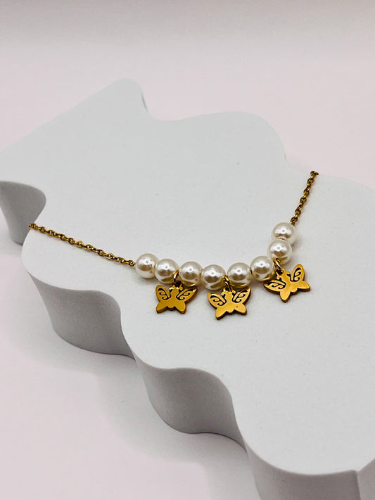 Con este hermoso collar lleva contigo la magia de las mariposas y el brillo de las perlas en cada ocasión.